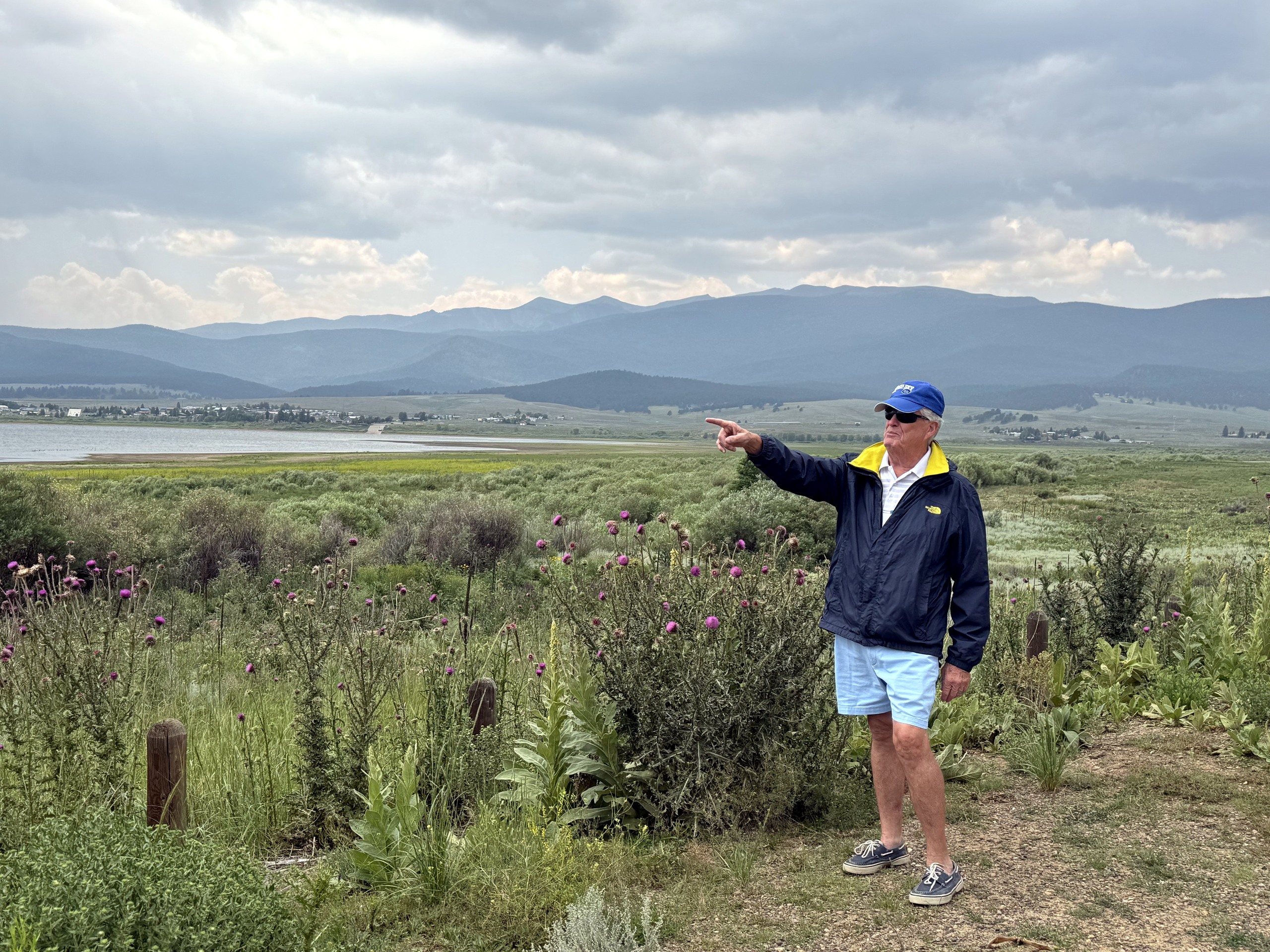 Drew Thacker pointing toward a distant mountain horizon
