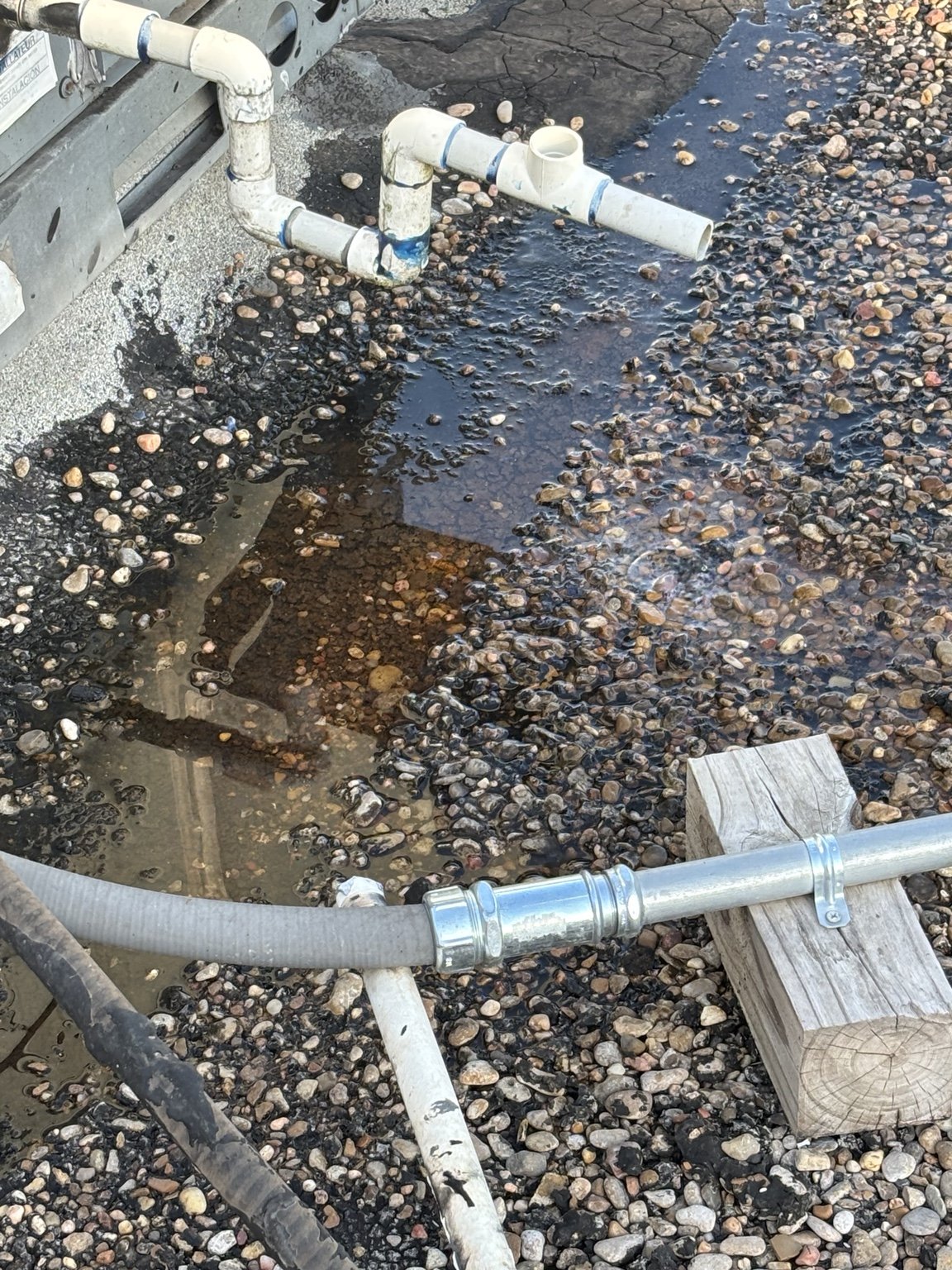 A condensate line cut and left to drain onto the aggregate roof. This is what the after-hours walkthrough was not going to show us.